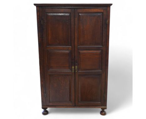 18th century oak larder cupboard, the projecting plain cornice over two triple-panelled doors, concealing three shelves, lowe