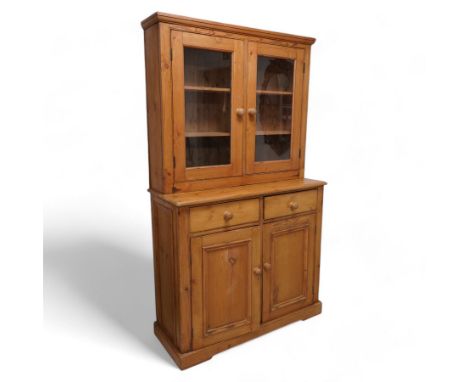 Late 20th century waxed pine dresser, raised display cabinet enclosed by two glazed doors, the base fitted with two drawers o