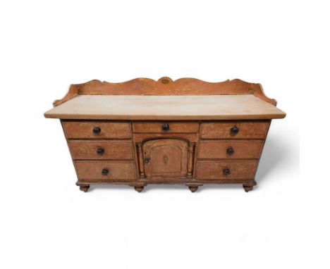 Victorian scumbled pine and sycamore dresser base, the sycamore top framed within shaped gallery, fitted with seven drawers a