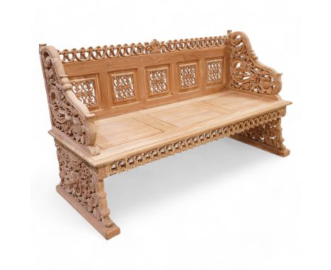 Hand carved teak garden bench, C-scroll and foliate carved cresting rail over four pierced and flower head carved panels, sha