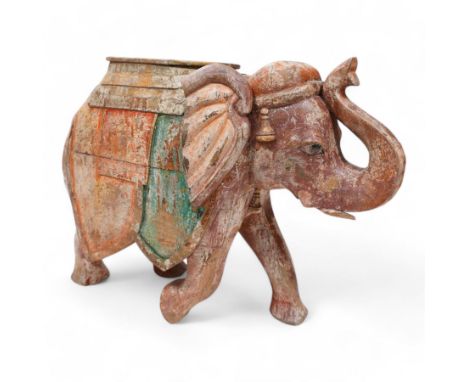 Early 20th century Indian hardwood and polychrome Elephant jardiniere stand, decorated with a headdress and vibrant saddle cl