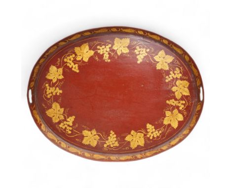 19th century red and parcel gilt toleware tray, of oval form with pierced handles, decorated with bands of fruiting vines and