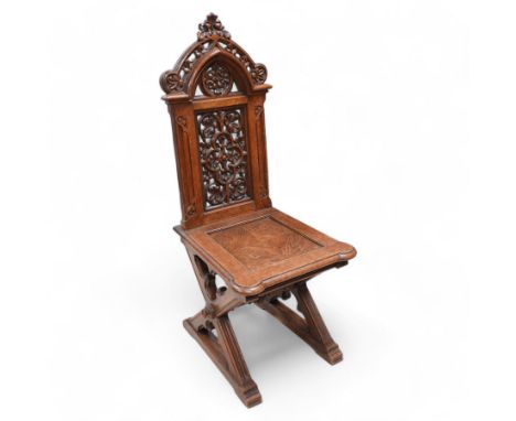 In the manner of Augustus Pugin - 19th century Gothic Revival carved oak hall chair, the pierced and carved arched pediment p