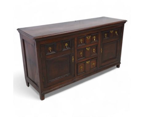 George III elm dresser base, the rectangular top with moulded edge, fitted with three central graduating twin-panelled drawer