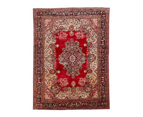 Persian Tabriz crimson ground carpet, central medallion with extending floral decoration on plain field, the ivory ground inn