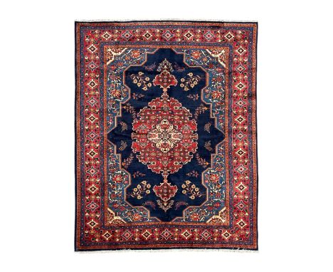 Persian Veis indigo ground carpet, the field with large pole medallion decorated with Herati motifs and surrounded by floral 