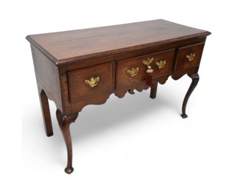 18th century oak dresser base, the rectangular top with moulded edge, fitted with three drawers with original brass handle pl