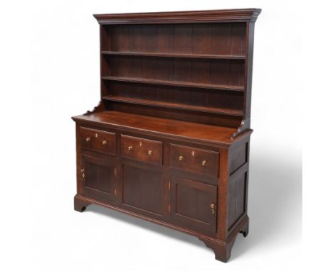 Late 18th century oak dresser, moulded cornice over three-tier plate rack, the base fitted with three drawers and two cupboar