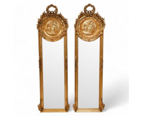 Pair of Victorian design gilt framed narrow wall mirrors, floral wreath pediment over ribbon tie and trailing flower heads, c