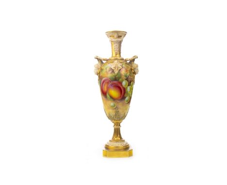 MID-20TH CENTURY ROYAL WORCESTER VASE, of slender urn form, with two head form handles, the body hand painted with fruits and