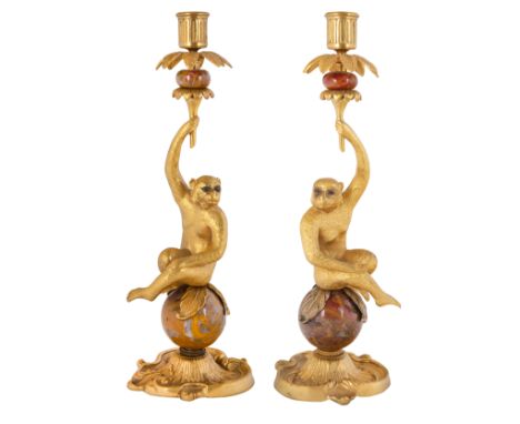 A PAIR OF FRENCH LOUIS XVI STYLE ORMOLU-MOUNTED RED ONYX MONKEY CANDLESTICKS, LATE 20TH CENTURYeach formed as a monkey with g