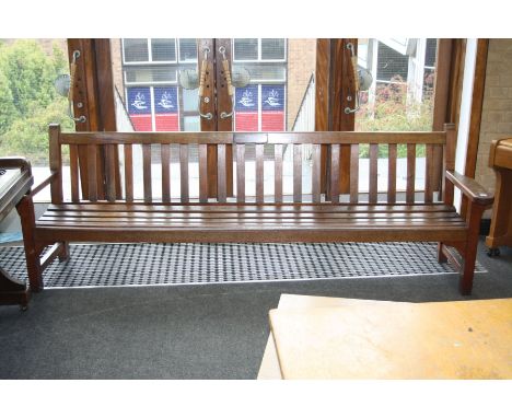 A TEAK SLATTED GARDEN BENCH, 253cm long with a presentation plaque dated 1969