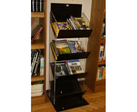 A BLACK AND CLEAR PERSPEX BOOK/MAGAZINE DISPLAY STAND, with four angled shelves, 48x45x143cm high