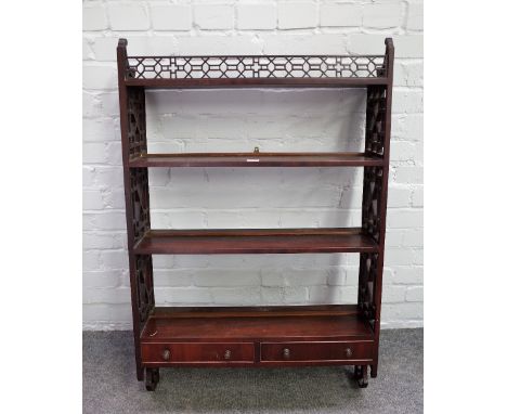 A 19th century mahogany four tier hanging wall shelf with fret carved decoration and pair of lower drawers, 67cm wide x 104cm