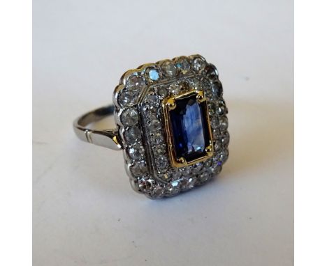 A diamond and sapphire set rectangular cluster ring, mounted with the rectangular step cut sapphire at the centre, in a two r