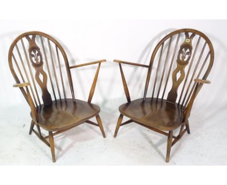 Ercol; a pair of ash and elm low stickback open armchairs, (2). 