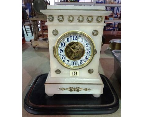 A French alabaster mantel clock, late 19th/early 20th century, with visible escapement and an Arts and Crafts style numerical
