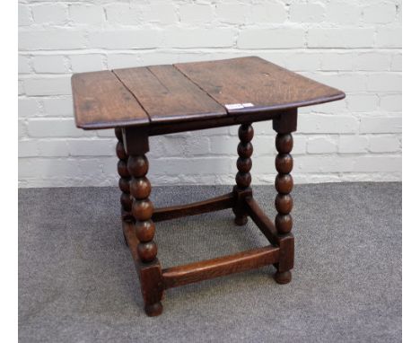 A 17th century oak low occasional table, the twin plank top on bobbin turned base, 55cm wide x 53cm high. 