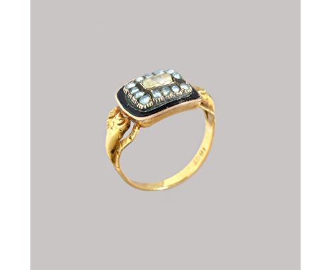 A Victorian gold, black enamelled and seed pearl set mourning ring, glazed with a central locket compartment, in a surround o