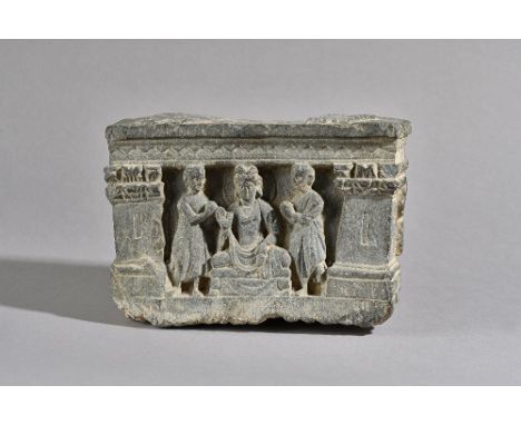 A Gandhara grey schist fragment from a statue base, 3rd/4th century, AD, depicting Buddha Maitreya flanked by devotees within
