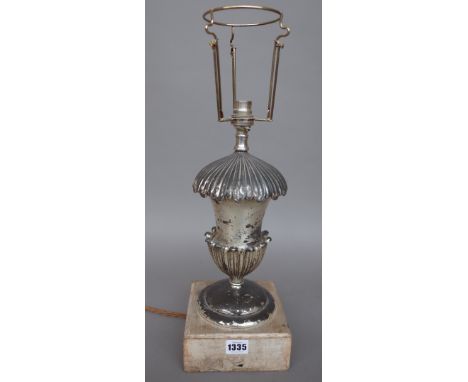 A silvered metal table lamp of urn form on a wooden plinth and an ebonised clock wall bracket with ormolu embellishments, 50c