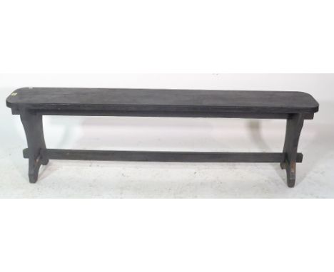 An early 20th century black painted bench on trestle supports, 150cm wide x 41cm high. 