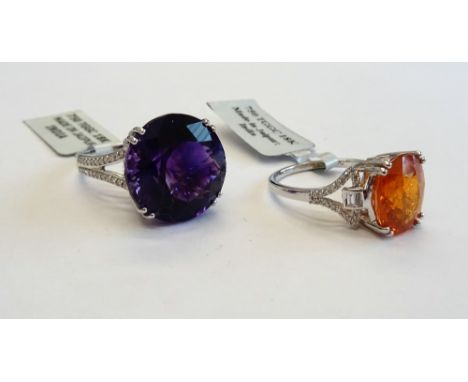 An 18ct white gold, amethyst and diamond ring, claw set with the circular cut amethyst between diamond set split V-shaped sho