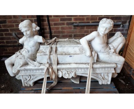 A marble chimney piece or fire surround with figural surmount and foliate relief carved supports, 140cm wide, (a.f.).  
