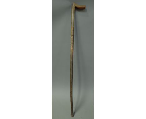 A rhinoceros horn walking stick, late 19th century, of sectional form with carved bands to the shaft. 84cm. 