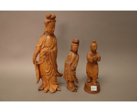 A Chinese boxwood figure of Guanyin, standing in long robes holding a scroll in her left hand, 24cm. high; also a smaller box