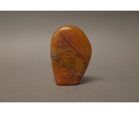 A Chinese brown soapstone seal, probably 18th century, of flattened boulder form, carved on one side with a figure in a boat 