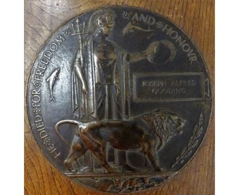 A First World War period bronze memorial plaque, detailed Joseph Albert Gooding, mounted to an oak display stand, J A Gooding
