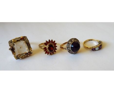 A 9ct gold and garnet set oval cluster ring (one garnet detached, but present), a cabochon amethyst and colourless gem set cl