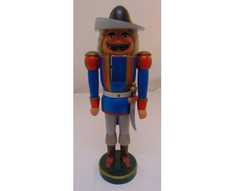A carved painted wooden German nutcracker in the form of a soldier on raised circular base, 53cm (h)