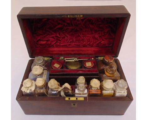A Victorian mahogany apothecary medicine cabinet the hinged cover revealing glass bottles some with sealed labels for R. Wood