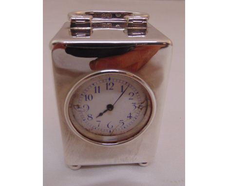 A hallmarked silver desk clock, rectangular with swing handle on four bun feet, white enamel dial, Arabic numerals, A/F, Lond