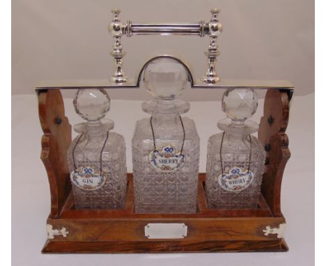 A three bottle Tantalus mahogany case with silver plated top and handle and three enamel wine labels, 34.5 x 36 x 15cm