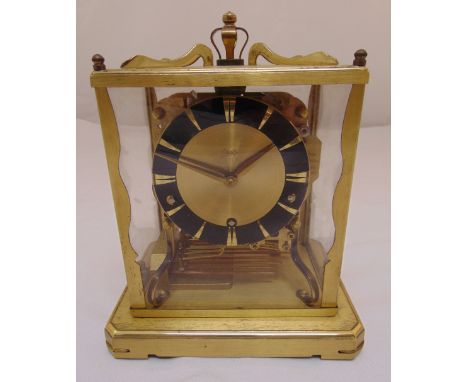 A gilded metal rectangular four glass chiming mantle clock with black chapter ring on raised square base, 24.5 x 19.5 x 15cm