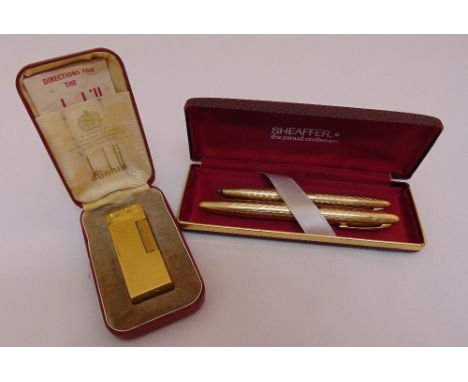 A Dunhill gold plated engine turned cigarette lighter in fitted case and a Sheaffer fountain pen and propelling pencil