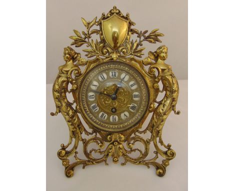 Art Nouveau brass easel clock, scroll pierced flanked with female figures, white enamel dial with Roman numerals, surmounted 