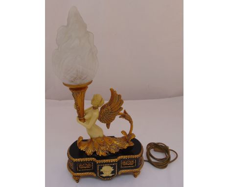 A Regency style table lamp in the form of a classical figurine supporting a torch on shaped rectangular base with four spool 