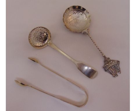 A silver sifter spoon, a Dutch white metal spoon with cast finial and a pair of hallmarked silver tongs, approx total weight 