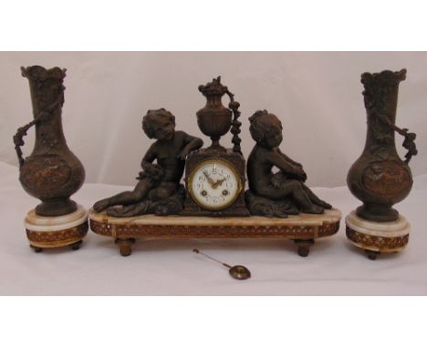 French bronzed mantle clock flanked by two putti and two vase form garnitures, clock 58cm (w) vases 34cm (h)