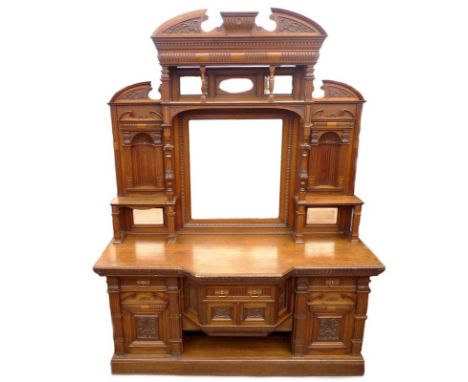 A large Victorian oak sideboard, mirrored back with alcoves, shelves, columns and pediments, all with carved decoration, scro