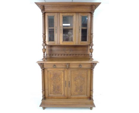 A 19th century French oak glazed hunting cabinet / buffet a deux corps, the upper section with wide cornice and two carved fa