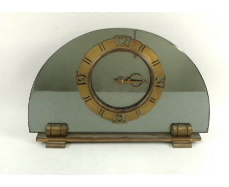 An Art Deco Smiths mantel clock, of semi circular mirrored form, with brass base and applied brass chapter ring, 30.5 by 19.5