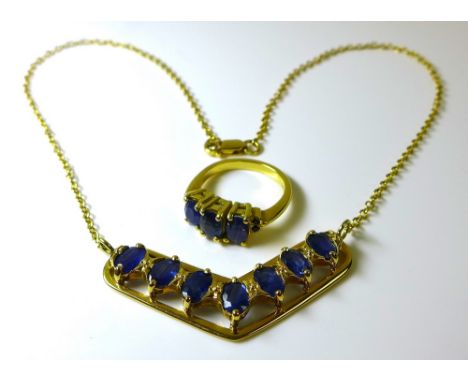 An 18ct gold and sapphire pendant necklace and matching ring, the necklace with v shaped pendant set with seven Columbian sap