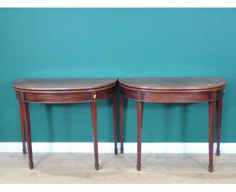 A pair of 19th Century mahogany demi-lune Card Tables with moulded fold-over tops and green baise lined playing surfaces moun