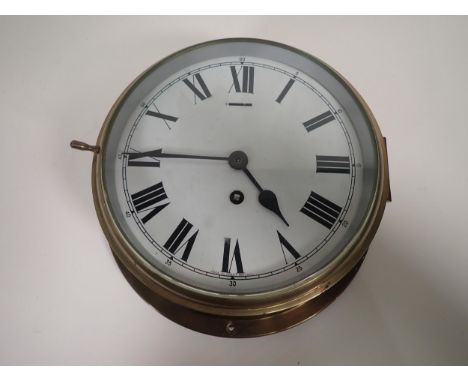 A brass cased circular Railway Clock with white enamel dial, having single train movement, 10in diam 