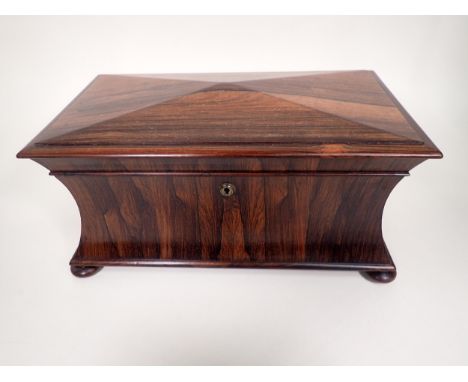 A 19th Century rosewood Tea Caddy of sarcophagus shape, with interior lidded boxes, ring handles on bun feet, 15in 